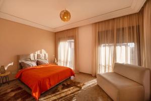 a bedroom with a bed and a couch at Villa Leya - Piscine chauffée in Marrakech +10 photos