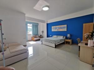 um quarto com paredes azuis, uma cama e um sofá em 小红马民宿 em Yinzhan'ao