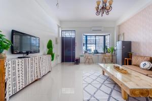 ein Wohnzimmer mit einem TV und einem Sofa in der Unterkunft Sakura B&B in Taitung