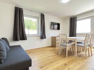 ein Wohnzimmer mit Tisch und Stühlen und einer Couch in der Unterkunft SAD150 - Moderne Monteurwohnungen in Schwandorf mit Balkon in Schwandorf in Bayern