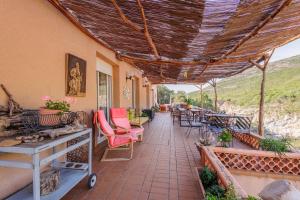 a patio with chairs and tables and a roof at Maison du Fangu - Da Simone - Maison de 160 m2 in Galeria
