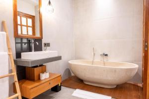 a bathroom with a large tub and a sink at Sudut Padi Villa Ubud by Omkara Experience in Ubud +16 photos