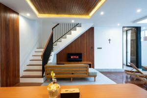 a living room with a staircase and a couch at Sudut Padi Villa Ubud by Omkara Experience in Ubud