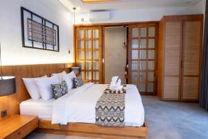 a bedroom with a large bed with white sheets at Sudut Padi Villa Ubud by Omkara Experience in Ubud