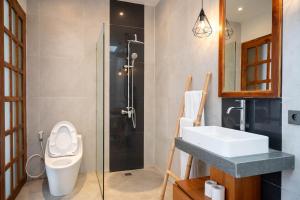a bathroom with a toilet and a sink and a shower at Sudut Padi Villa Ubud by Omkara Experience in Ubud