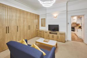 een woonkamer met een blauwe bank en een tv bij Host & Stay - Thamesview in Staines +7 foto's