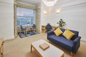 een woonkamer met een blauwe bank en een tafel bij Host & Stay - Thamesview in Staines