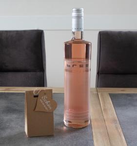 a bottle of wine sitting on a table with a tag at Ferienhaus Segelblick LUV in Holnishof