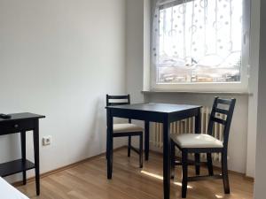 a black table and chairs in a room with a window at SAD161 - Gut geschnittene Monteurwohnung mit Balkon in Schwandorf in Bayern