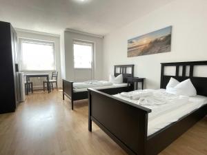 a bedroom with two beds and a table and chairs at SAD161 - Gut geschnittene Monteurwohnung mit Balkon in Schwandorf in Bayern
