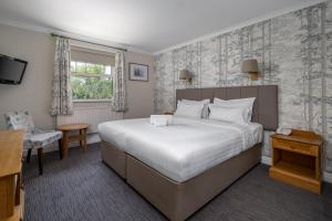 a hotel room with a large bed and a desk at Reigate Manor Hotel in Reigate