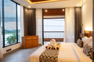 a bedroom with a large bed and a large window at Sudut Padi Villa Ubud by Omkara Experience in Ubud