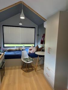 a bedroom with a bed and a table and a chair at Tiny Haus im Quittengarten in Distelhausen