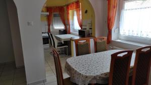 a dining room with a table and chairs and a kitchen at Kiss Vendégház in Balatonlelle
