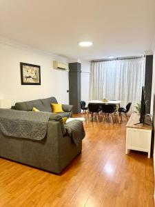 ein Wohnzimmer mit Sofa und Tisch in der Unterkunft 10 minutos centro Sevilla, moderno y con parking gratis in Sevilla