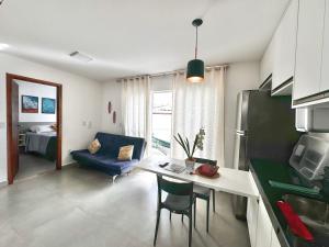 a kitchen and living room with a table and a couch at Flat Maré 3 - 2da praia condomínio com piscina, Morro de Sao Paulo in Morro de São Paulo +4 photos