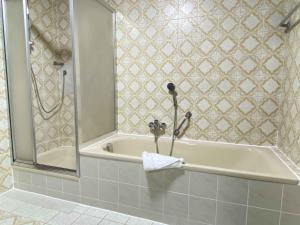 ein Bad mit einer Badewanne und einer Dusche mit einem Handtuch in der Unterkunft SAD200 - Komfortable Monteurwohnungen in Schwandorf in Schwandorf in Bayern