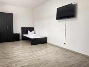 ein Zimmer mit einem Bett und einem Fernseher an der Wand in der Unterkunft SAD200 - Komfortable Monteurwohnungen in Schwandorf in Schwandorf in Bayern