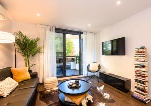 una sala de estar con un sofá y una mesa en Elwood stylish apartment in botanical location near beach, en Melbourne 10 fotos más