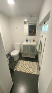 Un baño con lavabo, inodoro y espejo. en Villa Cardui. Casa de diseño con magníficas vistas, en Madrid 27 fotos más