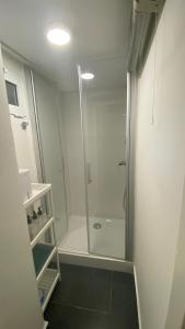 Un baño con ducha con puerta de cristal. en Villa Cardui. Casa de diseño con magníficas vistas, en Madrid