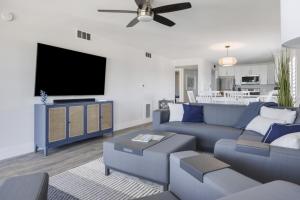 Una sala de estar con un sofá azul y un televisor de pantalla plana. en Pelicans Roost 307 condo, en Sanibel