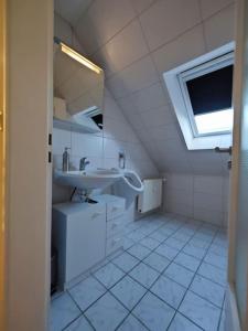 a white bathroom with a sink and a window at Ferien-Monteurwohnung NOM App2 Sky Terrasse High End in Northeim +7 photos