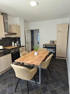 a kitchen with a wooden table and chairs at Ferienwohnung Freedom 2 Sky Terrasse High End in Northeim +5 photos