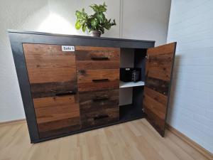 a wooden dresser with a potted plant on top of it at Ferienwohnung Freedom 2 Sky Terrasse High End in Northeim