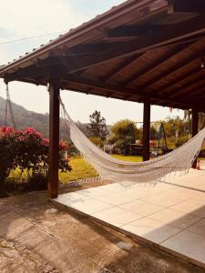 a hammock is hanging from a pergola at Oliveira montain House in Tijucas