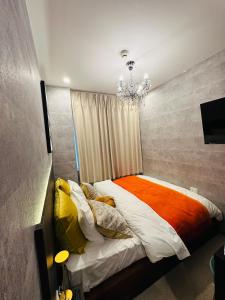 1 dormitorio con 1 cama con lámpara de araña en e-hostel 心斎橋 208, en Osaka