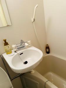 y baño con lavabo blanco y bañera. en e-hostel 心斎橋 208, en Osaka 18 fotos más