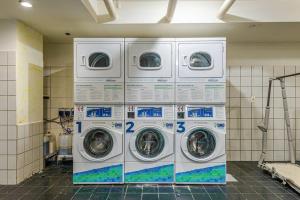four washing machines are stacked in a laundry room at Alphaville-Industrial com cozinha-piscina e academia-500mega in Barueri