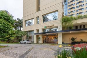 a car parked in a parking lot in front of a building at Alphaville-Industrial com cozinha-piscina e academia-500mega in Barueri