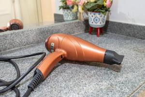 a blow dryer sitting on a counter with flowers at Alphaville-Industrial com cozinha-piscina e academia-500mega in Barueri