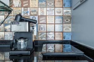 a coffee machine in a coffee shop with a tiled wall at Alphaville-Industrial com cozinha-piscina e academia-500mega in Barueri