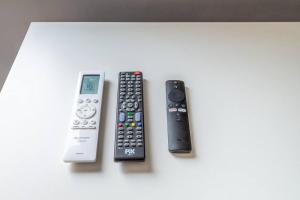 three remote controls sitting on top of a table at Alphaville-Industrial com cozinha-piscina e academia-500mega in Barueri