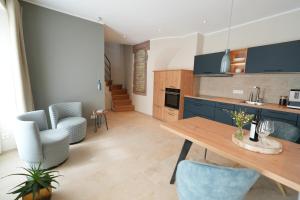 een keuken met een houten tafel en blauwe kasten bij Charmantes Chateau Lichter - Alte Schmiede in Ließem