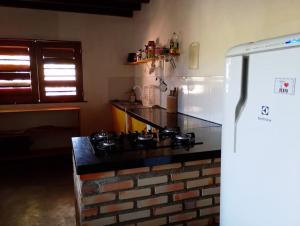 a kitchen with a stove and a refrigerator at Barefoot KiteHouse in Luis Correia