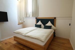 een slaapkamer met een bed met witte lakens en blauwe kussens bij Charmantes Chateau Lichter - Alte Schmiede in Ließem