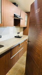 una cucina con armadi in legno e una porta in legno di Globe Home a Dehradun
