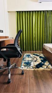 una sedia da ufficio davanti a una tenda verde di Globe Home a Dehradun