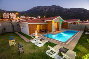 ein Hinterhof mit einem Swimmingpool und einem Haus in der Unterkunft Tlos Yalı 3+1 Villa, Özel Havuzlu, Fethiye in Fethiye