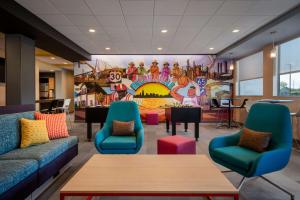 a waiting room with colorful furniture and a mural at Tru By Hilton Merrillville in Merrillville