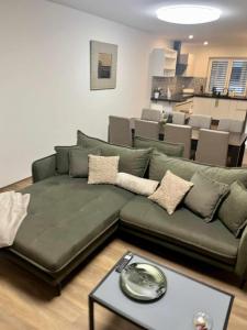 a living room with a green couch and a table at Vila EMMA in Prostějov