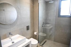 a bathroom with a sink and a toilet and a mirror at Amalia Sea Hotel in Rhodes Town +47 photos