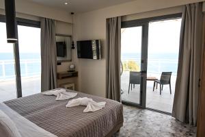 a bedroom with a bed and a view of the ocean at Amalia Sea Hotel in Rhodes Town