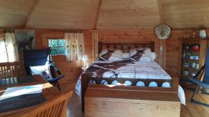 a bedroom with a bed in a log cabin at Chalet-Sauna-Evasion Nature et Bien-être in Gosnay