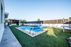 a pool with a slide in the middle of a yard at Ereza Villas Alicia in Caleta De Fuste
