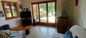 a living room with a couch and a table and a door at Casa in Maremma in Montemerano